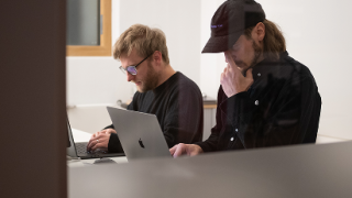 UI/UX Designer bei konzentrierter Arbeit an MacBooks