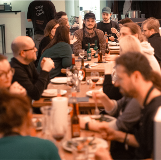 Viele Mitarbeitende von .diff sitzen zusammen beim gemeinsamen Abendessen