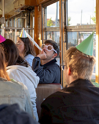 .diffie mit Tröte in historischer Straßenbahn bei Firmenevent